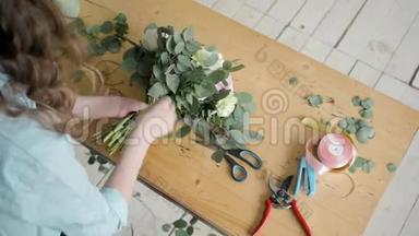 女花艺师在<strong>鲜花店</strong>制作美丽的花束，为婚礼准备佩恩和玫瑰花构图